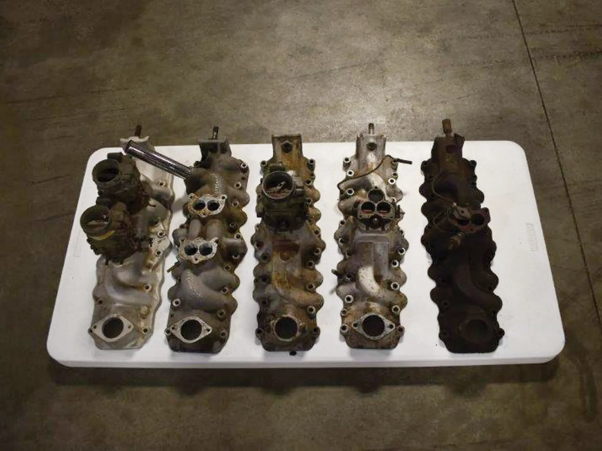 Group of five Ford early V8 manifolds, some with carburetors Auburn