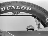 Chassis no. 5893, NART entry #21, races under the iconic Dunlop Bridge at the 1965 24 Hours of Le Mans.