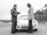 Jürgen Barth (right) and a journalist from Autosport discuss the performance of this Carrera RS during the press release, Hockenheimring, 1973.