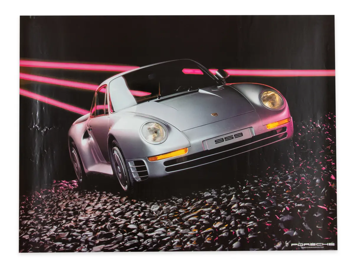 canted or tilted image of silver porsche 959 sitting on a bed of rocks in the dark with the 80s or 90s hot pink neon stripes of lights behind it