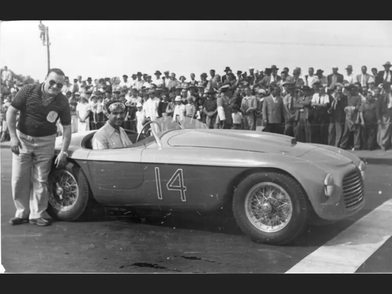 Carlos Menditeguy posing for a photograph with chassis 0024, following his victory at the Playa Grande circuit in Argentina on 15 January 1950.