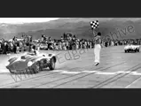 Al Torres waves the checkered flag as Carroll Shelby in the Edgar Ferrari 410 Sport bests Phil Hill in the Ferrari Monza at Palm Springs, November 1956.