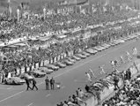 Drivers sprint to their cars as the starter flag is waved at the 1965 24 Hours of Le Mans.