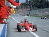 Michael Schumacher, pictured in the Ferrari F2002, raises his fist in victory at the 2002 San Marino Grand Prix.