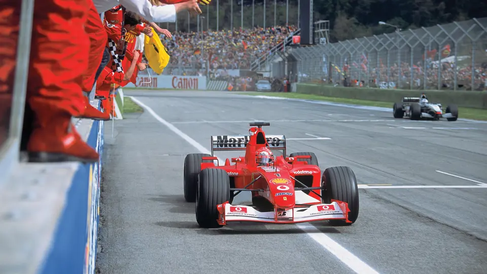 Michael Schumacher, pictured in the Ferrari F2002, raises his fist in victory at the 2002 San Marino Grand Prix.