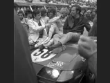 Bob Grossman and Luigi Chinetti Jr hold court on the bonnet of their historic Daytona, as a crowded pit lane watches on.