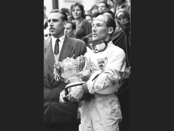 Stirling Moss stands proudly holding the 1st-Place Trophy he won at the 1961 Monaco Grand Prix.