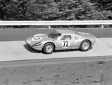 The svelte Porsche hurtles down a banked section of track at the 1965 Nürburgring 1000 Kilometres, drivers Udo Schütz and Anton Fischhaber finished 1st in the GT class.