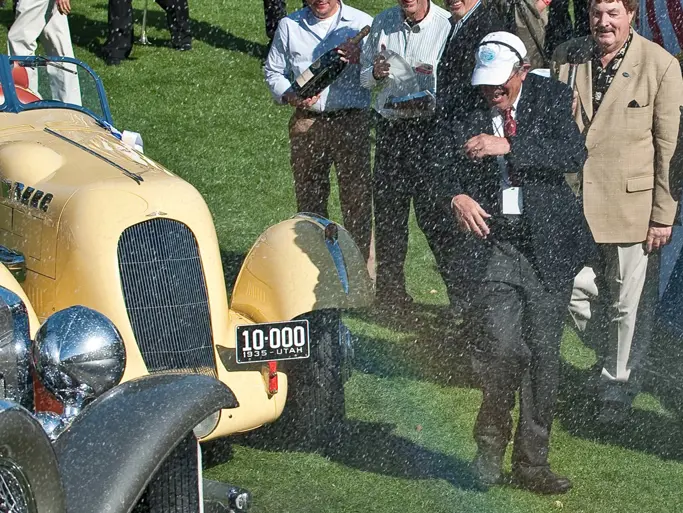 Amelia Island Concours dElegance founder Bill Warner being sprayed with champagne