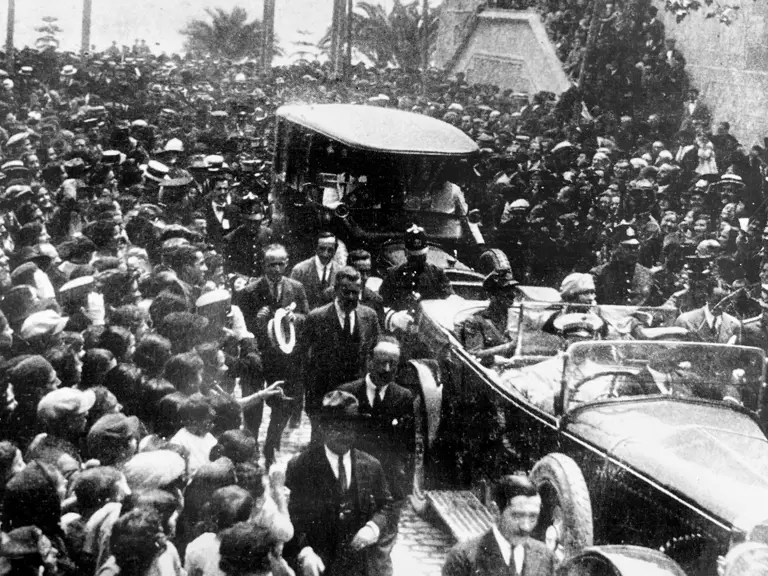 This Hispano H6, driving through a crowded street behind the Daimler of Queen of Spain, Victoria Eugenie of Battenburg.