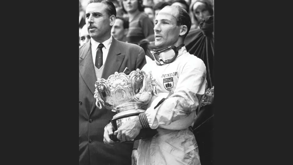 Stirling Moss stands proudly holding the 1st-Place Trophy he won at the 1961 Monaco Grand Prix.